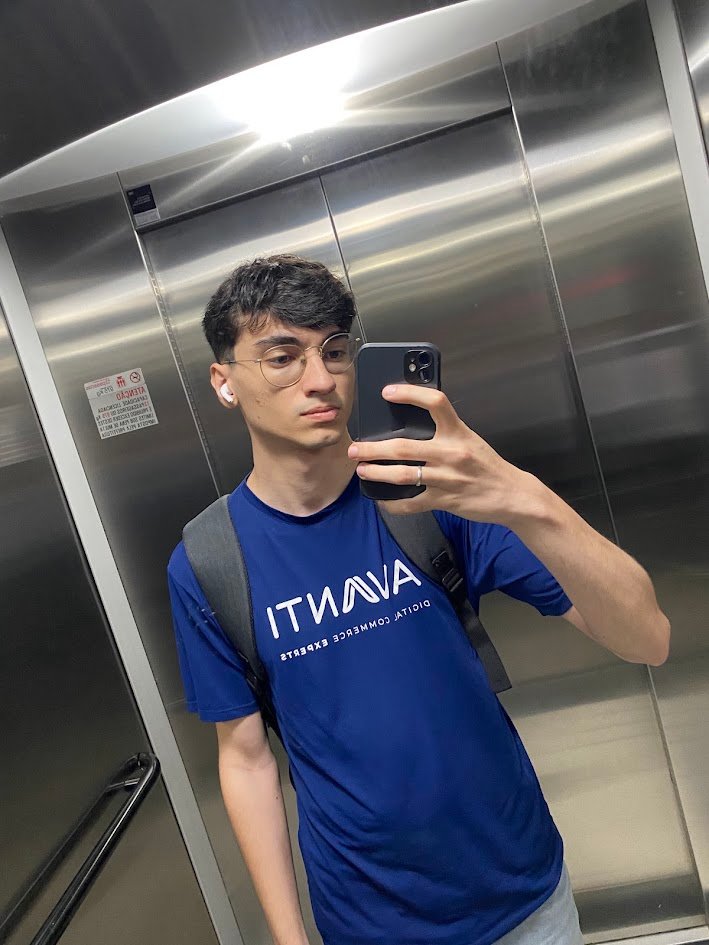 Henrique tirando uma selfie no espelho do elevador, com a camiseta azul da AVANTI